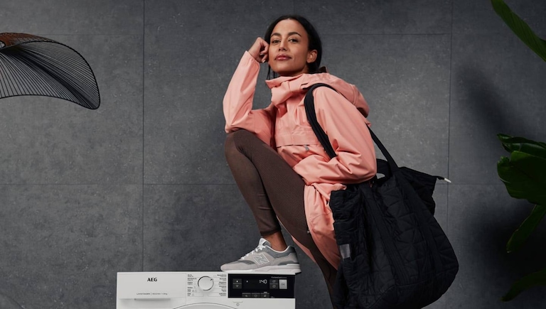 Woman leaning against an AEG washer-dryer.